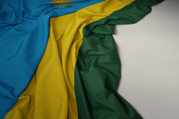 waving national flag of rwanda on a gray background.