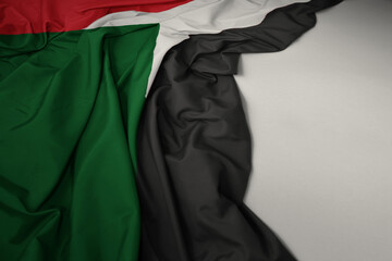 waving national flag of sudan on a gray background.