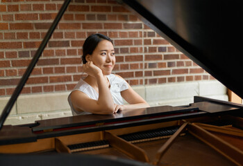 Asian woman, musician and thinking with piano for career, art or music with instrument. Female...