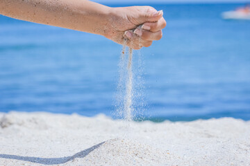 A Hands pour sand off the sea on nature on a journey. Vacations at sea sand time passes. - 787499837