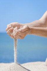 A Hands pour sand off the sea on nature on a journey. Vacations at sea sand time passes. - 787499853