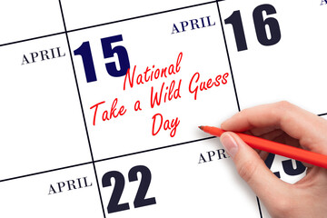 April 15. Hand writing text National Take a Wild Guess Day on calendar date. Save the date.