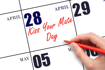 April 28. Hand writing text Kiss Your Mate Day on calendar date. Save the date.