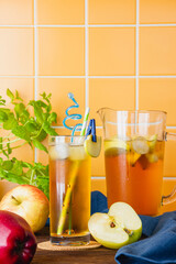 Apple cider in a glass jug on a wooden table