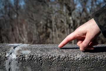Hand on a stone railing, stone pillars as a support