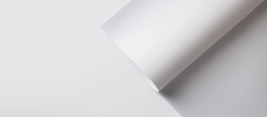 Blank white sheet of paper with a rounded corner, placed on a white background, seen from above.