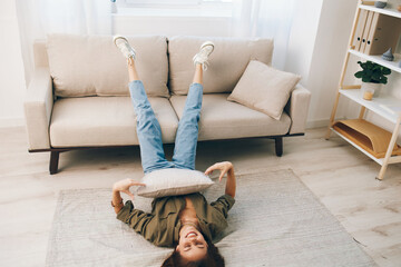 Relaxing at Home: A Cosy, Modern Apartment with a Happy Woman Lying on the Sofa