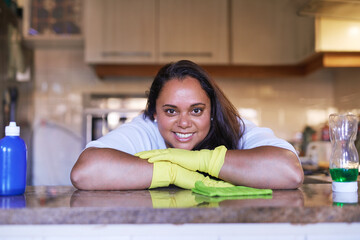 Woman, portrait and wipe surface of table in home, maid and disinfection for hygiene or housekeeping. Female person, dust and fabric or cloth to tidy, bacteria and gloves to protect from germ or dirt
