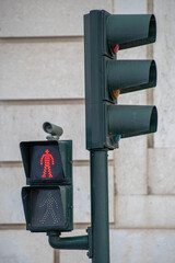 Red pedestrian crossing traffic light with blurred background of another traffic light