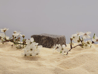 Stack of stones, flower platform podium on beige sand background. Minimal empty display product presentation scene.