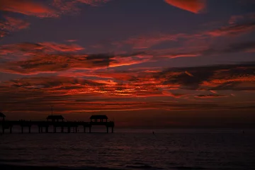 Photo sur Plexiglas Clearwater Beach, Floride beautiful red sunset in Clearwater Beach Florida, red sunset over the ocean with a pier in the foreground
