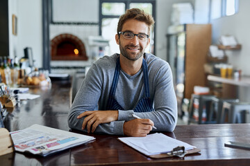 Coffee shop, worker and portrait of man with clipboard in restaurant for stock, inventory and review. Cafe, small business and waiter with paperwork on table for feedback, planning and price list