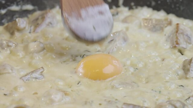 Preparation of black truffle sauce. The cook adds raw egg yolk to spaghetti, pasta sauce. 4k slow motinon 100fps video.