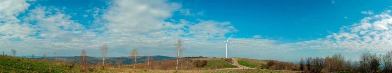 Wind turbine for alternative energy in mountain landscape with clear space background. The concept of clean energy, eco-energetics of the wind.