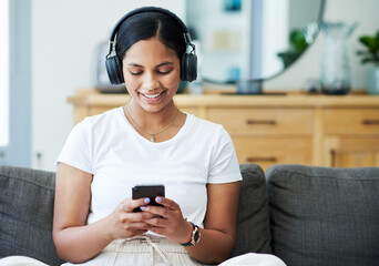 Home, cellphone and woman with headphones, smile and listening to podcast with live streaming music...
