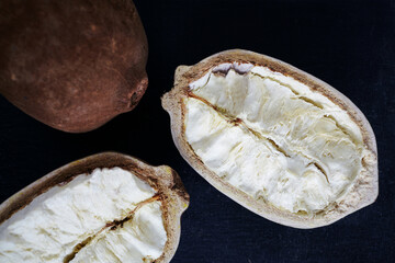 Fresh cupuacu fruit on a black wooden table. Substitute of cacao, coco