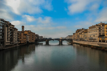 bridge over arno in florence, with buildings around on the banks - obrazy, fototapety, plakaty