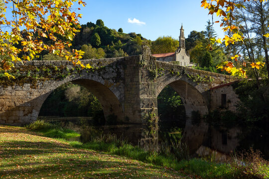 Romanesque stone bridge and Santa María de Vilanova church in the beautiful village of Allariz in autumn, Orense, Galicia, Spain.