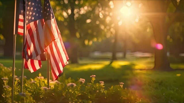 American flags flutter gently among blooming flowers, bathed in the golden glow of early morning sunlight.