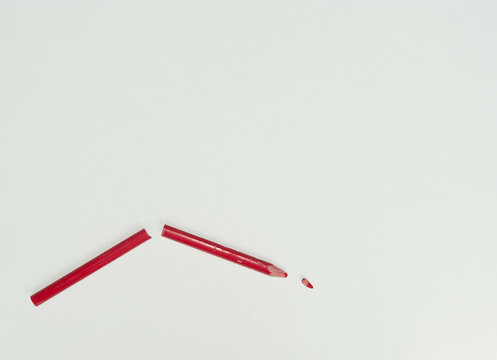 Broken red pencil on a white background