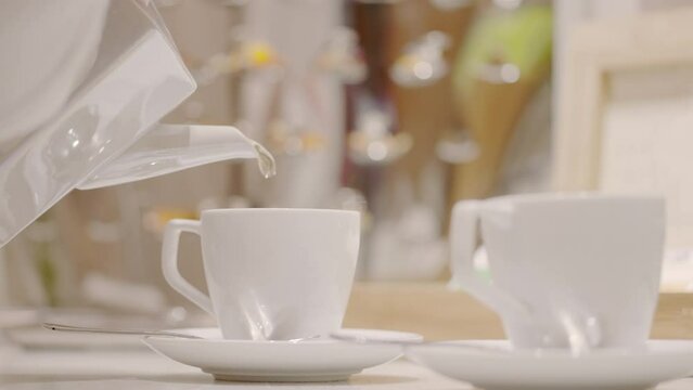 Tea is poured into a luxurious white teacup in a hotel setting