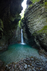 Caporetto, Slovenia. Kozjak waterfalls. Nature trail along the river with crystal clear, turquoise water, Tibetan bridges and a waterfall inside the cave with a nature pool. easy trekking, wood path.