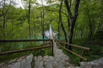 Caporetto, Slovenia. Kozjak waterfalls. Nature trail along the river with crystal clear, turquoise water, Tibetan bridges and a waterfall inside the cave with a nature pool. easy trekking, wood path.