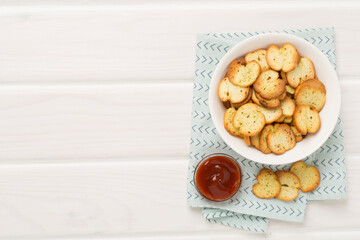 Spiced bruschette chips on wooden background, top view