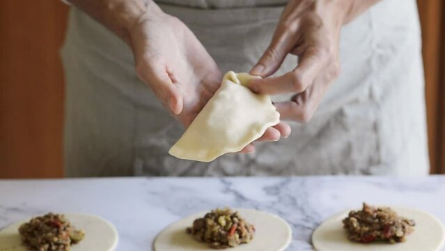 The process of sealing Argentinian beef empanadas. How to make the traditional repulgue.