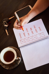 Person writing, tick or hands with notebook and schedule for daily routine, checklist with coffee....
