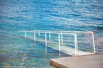 White metal railing on the pier in the sea. Summer sea background