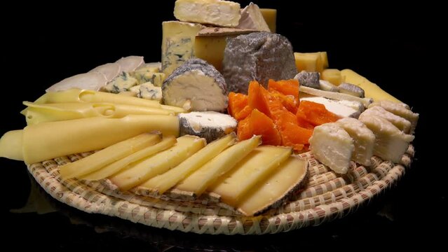Panorama of a large cheese plate of a variety of French cheeses. High quality 4k footage