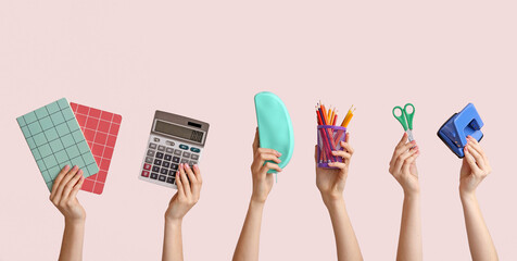 Many hands with school supplies on light background