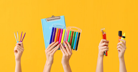 Many hands with school supplies on color background - obrazy, fototapety, plakaty