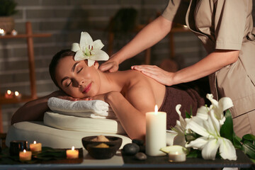 Young woman getting massage in dark spa salon, closeup - obrazy, fototapety, plakaty