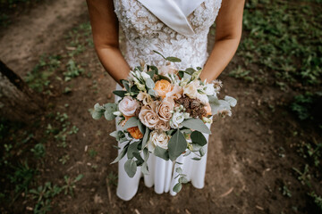 Valmiera, Latvia- July 28, 2024 - Close-up of a bride holding a bouquet with various flowers and...