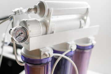 Pressure gauge and mineralizer in a reverse osmosis system for water purification at home. 