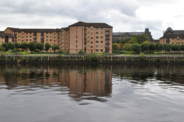 Riverside Apartment Buildings Reflected in Still Water 