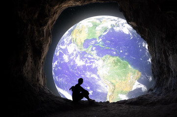 Earth day a man looking to view of the planet earth from cave hole in fancy image in save earth...