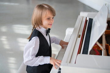A young boyis playing the piano.