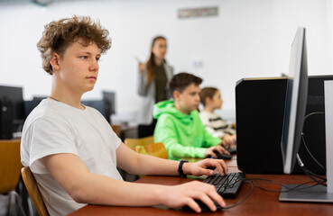 Modern teenage student learning basics of programming in group course in computer college