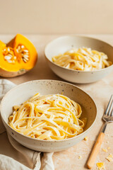Tempting fettuccine pasta with grated cheese and pumpkin on a rustic table setting