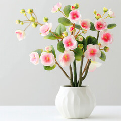 Lifelike pink artificial orchids with green leaves in a modern white pot against a light background.