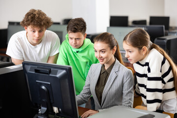 Fototapeta premium Teacher helping young student in computer class in university