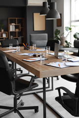 Table with stationery and armchairs prepared for business meeting in modern conference hall