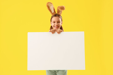 Cute little girl with Easter bunny ears and blank poster on yellow background