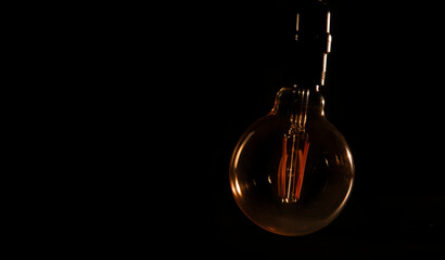 Unlit glass bulb without electricity hanging with warm reflections