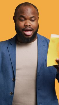 Vertical video Man reading book aloud, narrating story for audience, doing monologue for theatre play. Person rehearsing using literature novel source material, reciting from pages, studio background