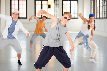Team of young dancers training street dance moves and having fun