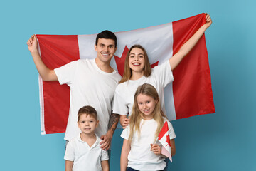 Beautiful family with flags of Canada on blue background - obrazy, fototapety, plakaty